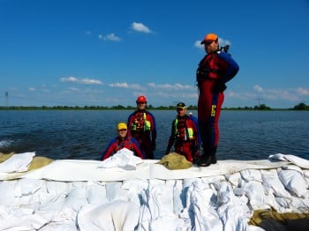 Strömungsretter warten auf weitere Sandsäcke zum verbauen