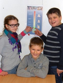 Jolin, Nils und David aus der 4b der Grundschule Benninghausen zeigen an der CO2-Ampel, dass bei ihnen die Luftqualität im grünen Bereich liegt (Foto: Stadt Lippstadt).