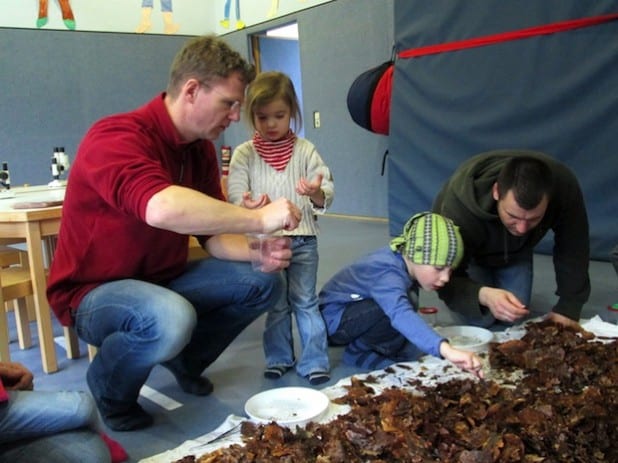 Diplom-Biologe Tim Graumann (l.) zeigte den „Kleinen vom Erbenberg“ die Geheimnisse eines Laubhaufens. Die Kids und ihre Väter waren im Workshop am Erbenberg begeistert bei der Sache (Foto: Stadt Iserlohn).