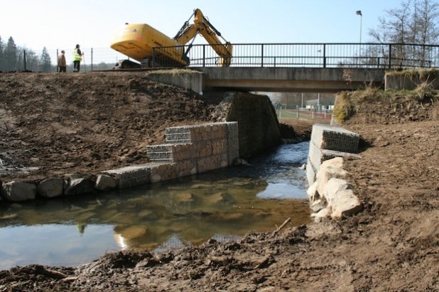 Die Gabionen verengen den Durchlass unter der Brücke. Dies hat bei Hochwasser zur Folge, dass sich der Wildenbach in den abgesenkten Uferbereich und das Naturschutzgebiet ausdehnen kann (Foto: Gemeinde Neunkirchen).