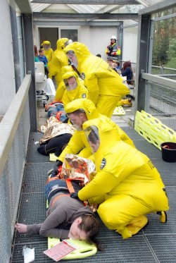Rettungskräfte in Schutzanzügen kümmerten sich um die kontaminierten Menschen (Foto: Karsten Grobbel, Feuerwehr Lennestadt).