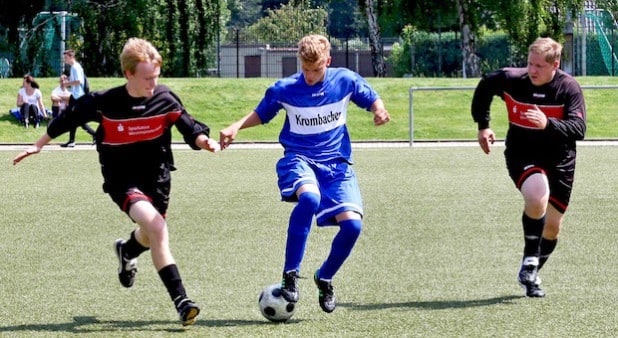 Schiedsrichter Benedikt Schneider vom Siegener SC (Mitte) im Kampf um den Ball (Foto: David Hennig).