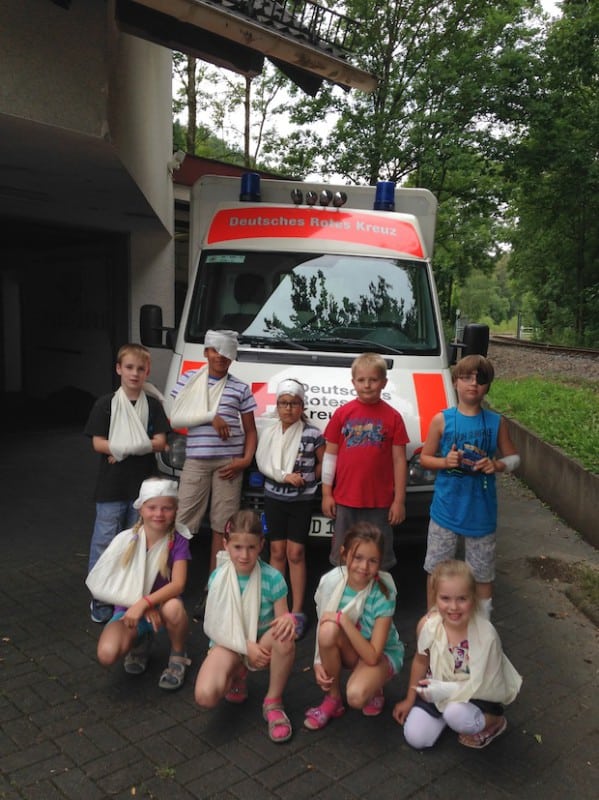 Mit dicken Verbänden ausgestattet, erkundeten die Kinder der Netphener Ferienspiele das DRK in Deuz. Das Highlight war die Besichtigung des Krankenwagens (Foto: DRK-Kreisverband Siegen-Wittgenstein e.V.).