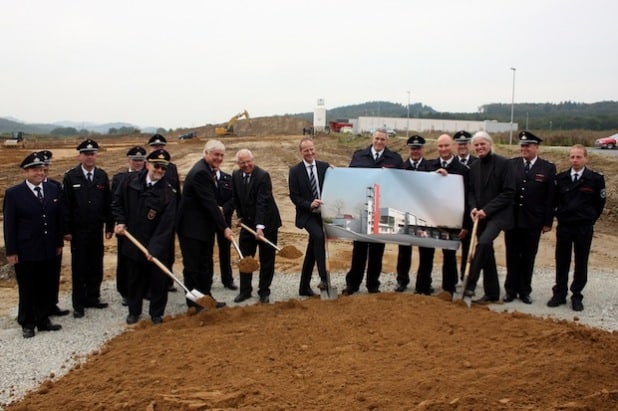 Am Spaten (v.l.n.r.): Kreisbrandmeister Martin Rickert, Meschedes Bürgermeister Uli Hess, Landrat Dr. Karl Schneider, Falko Derwald (Geschäftsführer der Unternehmensgruppe Derwald) und Thomas Pape (Architekt und Projektentwickler bei der Unternehmensgruppe Derwald). Im Hintergrund die Wehrleiter und Mitglieder der Freiwilligen Feuerwehren aus den Städten und Gemeinden (Foto: Pressestelle HSK).