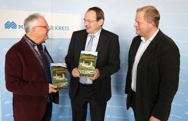 Autor Joachim Nierhoff (links) überreicht Landrat Thomas Gemke seinen neuen Bildband. Rechts Markus Holzhauer vom Sutton Verlag (Foto: Hendrik Klein/Märkischer Kreis).