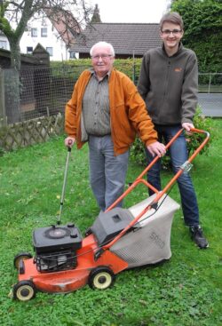 Tom Weber (r.) ist da, wenn Hilfe gebraucht wird. Er unterstützt Ulrich Klein u.a. beim Rasenmähen (Foto: Gemeinde Burbach).