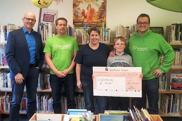 Die Leiterin der Wilnsdorfer Bibliothek, Sabine Flecke, freut sich gemeinsam mit Wilnsdorfs 1. Beigeordneten Helmut Eich (l.) über den großen Spendenscheck, den die 57wasser-Gründer Dirk Krumpholz (2.v.l.) und Björn Bach (r.) überreichten (Foto: Gemeinde Wilnsdorf).