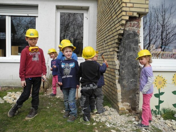 Mit Hammer und Schutzausrüstung legten die Kinder des Kindergartens Würgendorf schon los und läuteten den Abbruch des Gebäudes ein (Foto: Gemeinde Burbach).