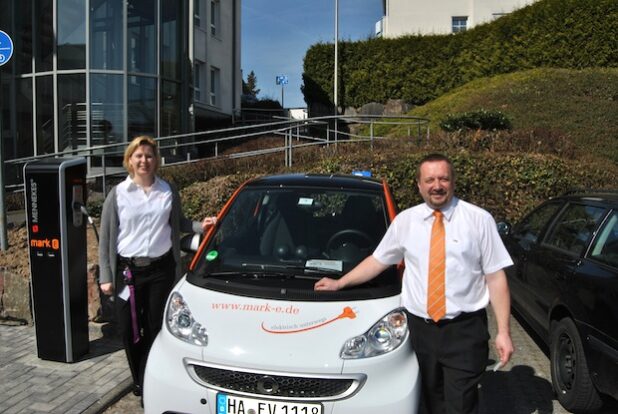 Daniela Grundmann (Kundenberatung) und Dirk Kattwinkel (Verkauf) an der Ladesäule für E-Mobile