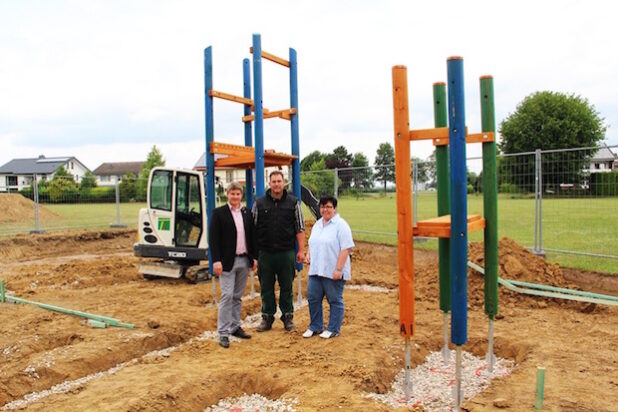 Thomas Baumhögger von der ausführenden Baufirma aus Salzkotten (M.) klärte Bürgermeister Dr. Remco van der Velden und Verwaltungsmitarbeiterin Rita Lemke über den Baufortschritt des neuen Spielgerätes auf dem Bolzplatz „Auf den Strickern“ auf (Foto: Stadt Geseke).