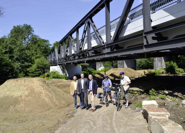 Stadtplaner Thorsten Grote, Baudezernent Mike Janke und Bürgermeister Dr. Peter Paul Ahrens (v.l.) machten sich am Freitag, 10. Juli, ein Bild von dem fertig gestellten „Bike Park Letmathe“ und der sanierten Kreisbahnbrücke. Zwei Radler des ADFC kamen bei der Gelegenheit mit den Vertretern der Stadt ins Gespräch (Foto: Stadt Iserlohn).