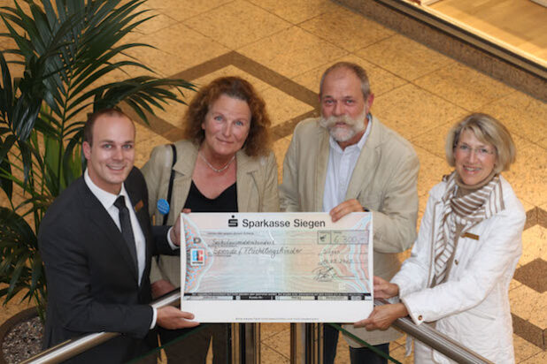 Spendenübergabe im Rahmen der großen Bücheraktion in der City-Galerie. Im Bild von links: Center Manager Patrick Homm, Angelika Gruß (Unicef), Reimund Ditsche (Stichting for school an life) sowie Gabriele Fleschenberg (Soroptimists Siegen) - Foto: City-Galerie Siegen (ECE).