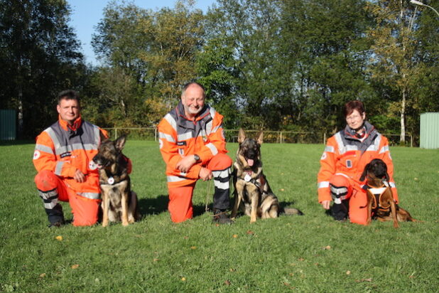 Bestanden jetzt die DRK-Rettungshundeprüfung: Andreas von Bülow mit Paika, Günter Scheid mit Gloria (beide Fläche) und Brigitte von Szczawinski mit Mantrailer Heidi (v.l.) vom DRK-Kreisverband Siegen-Wittgenstein - Foto: DRK-Kreisverband Siegen-Wittgenstein e.V.