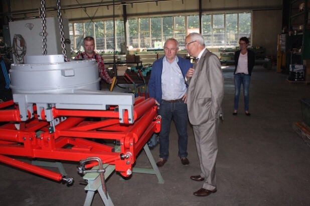 Landrat Dr. Karl Schneider (r.) wird von Geschäftsführer Josef Hanses (M.) durch die Fertigungshalle geführt (Foto: Pressestelle HSK).