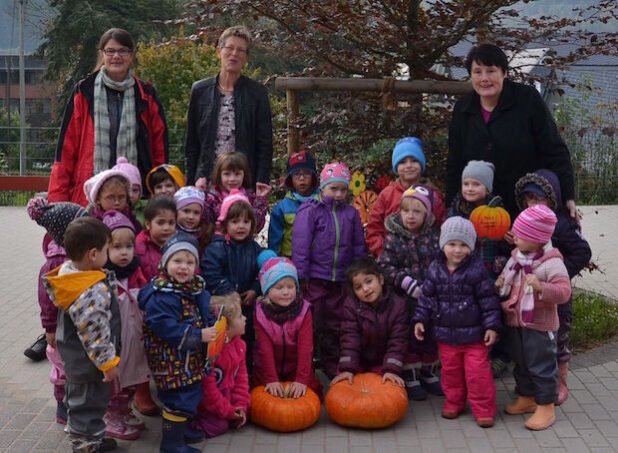 (von links) Birgit Frerig-Liekhues, Klimaschutzmanagerin der Stadt Hilchenbach, Juliane Scheel, Stadtsparkasse Hilchenbach und Renate Langenbach, Leiterin der evangelische Kita in Dahlbruch und die Kinder der Einrichtung freuen sich über den 2. und 3. Platz im Kürbiswettbewerb. Das gewonnene Geld, 250 Euro, soll in eine Sofaecke investiert werden.) - Quelle: Stadt Hilchenbach