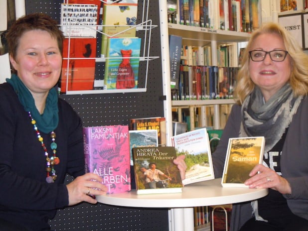 Monika Schröder (links) von der Buchhandlung MankelMuth überreicht Büchereileiterin Gabriele Klotz die signierten Exemplare der Literaturpflaster Autoren „Indonesien“ - Foto: Stadt Bad Berleburg.