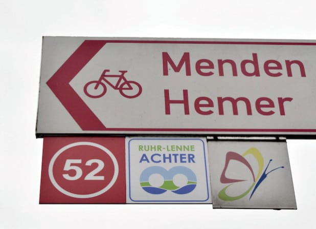 Die neuen „Knotenpunkt-Ziffern“ und Richtungshinweise an der vorhandenen rot-weißen Beschilderung weisen Radfahrern den richtigen Weg (Foto: Stadt Iserlohn).