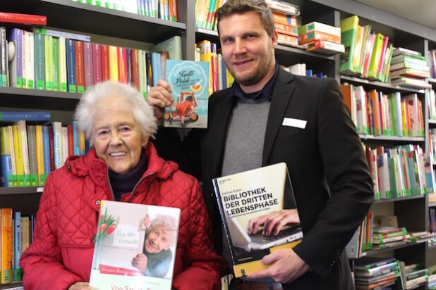 Leserin Maria Hüffer aus Rüthen und Nils Bald, Leiter der Fahrbücherei des Kreises Soest, freuen sich über das neue Bücherangebot für Seniorinnen und Senioren (Foto: Sebastian Gust/Kreis Soest).