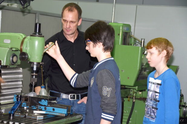 Berufsfelderkundung in der Firma Lumberg Connect GmbH, Martin Eilbrecht zeigt Marvin den richtigen Umgang mit einer Bohr-Fräsmaschine (Foto: Herget/Märkischer Kreis).