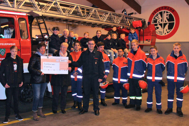 Monika Lepper und Rosi Hahlbrauck vom Handarbeitskreis überreichen Jugendfeuerwehrleiter Julian Hageböck einen Scheck in Höhe von 300 Euro (Foto: Feuerwehr der Gemeinde Finnentrop).