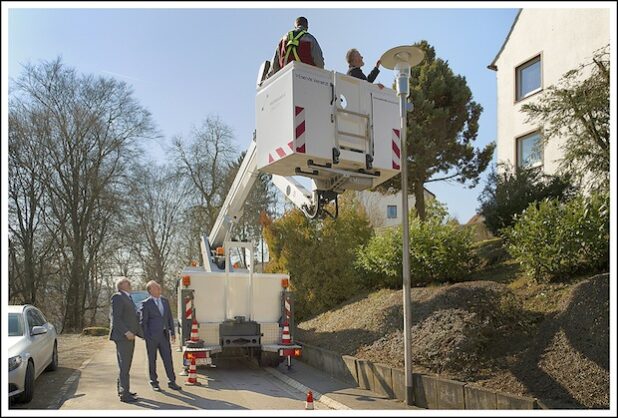 Heino Lange (links), Bürgermeister Dieter Dzewas und STL-Werkausschussvorsitzender Bernd Schildknecht (auf dem Steiger) machen sich vor Ort ein Bild vom Austausch der Leuchtmittel. Quelle: Stadt Lüdenscheid