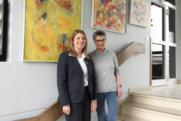 Die Anzhäuser Künstlerin Marion Berger (r.) stellt zurzeit im Wilnsdorfer Rathaus aus, Bürgermeisterin Christa Schuppler durfte als erste die dynamisch wirkenden Bilder sehen (Foto: Gemeinde Wilnsdorf).