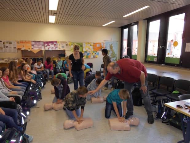 Ansgar Rocholl und Lisa Pilsl ermutigen die Schüler bei der Herzdruckmassage. (Quelle: Marienkrankenhaus Soest)